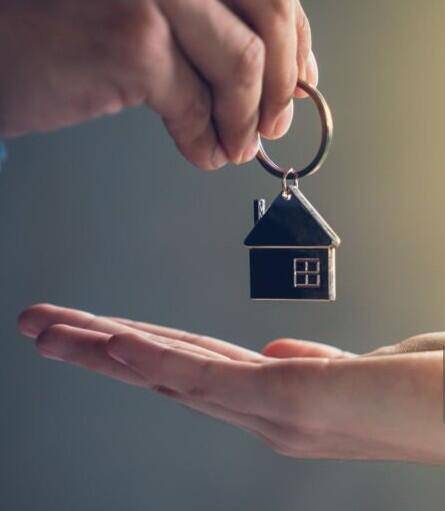 una mano passa la chiave di una casa in un altra mano